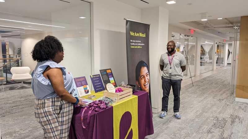 Bixalers Nita Johnson and Ernest Cain standing by a company welcome booth.